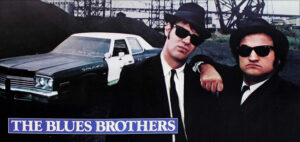 After his release from prison, Jake (John Belushi) reunites with his brother, Elwood (Dan Aykroyd) -- collectively known as the "Blues Brothers." Jake's first task is to save the orphanage the brothers grew up in from closing, by raising $5,000 to pay back taxes. The two are convinced they can earn the money by getting their old band back together. However, after playing several gigs and making a few enemies, including the police, the brothers face daunting odds to deliver the money on time.