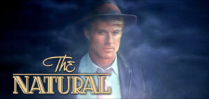 On the way to a tryout with the Chicago Cubs, young baseball phenom Roy Hobbs (Robert Redford) is shot by the unstable Harriet Bird (Barbara Hershey). After 16 years, Hobbs returns to pro baseball as a rookie for the last-place New York Knights. Despite early arguments with his manager, Pop Fisher (Wilford Brimley), Hobbs becomes one of the best players in the league, and the Knights start winning. But this upsets the Judge (Robert Prosky), their owner, who wants Hobbs to lose games, not win.
